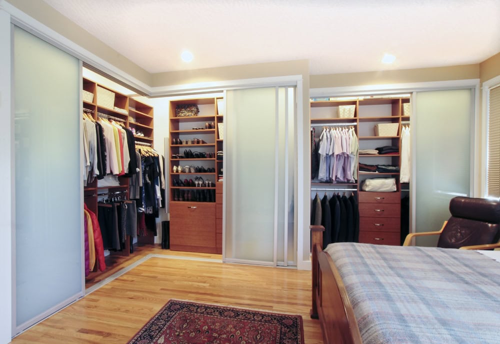 photo of a bedroom with a custom closet by Incredible Home